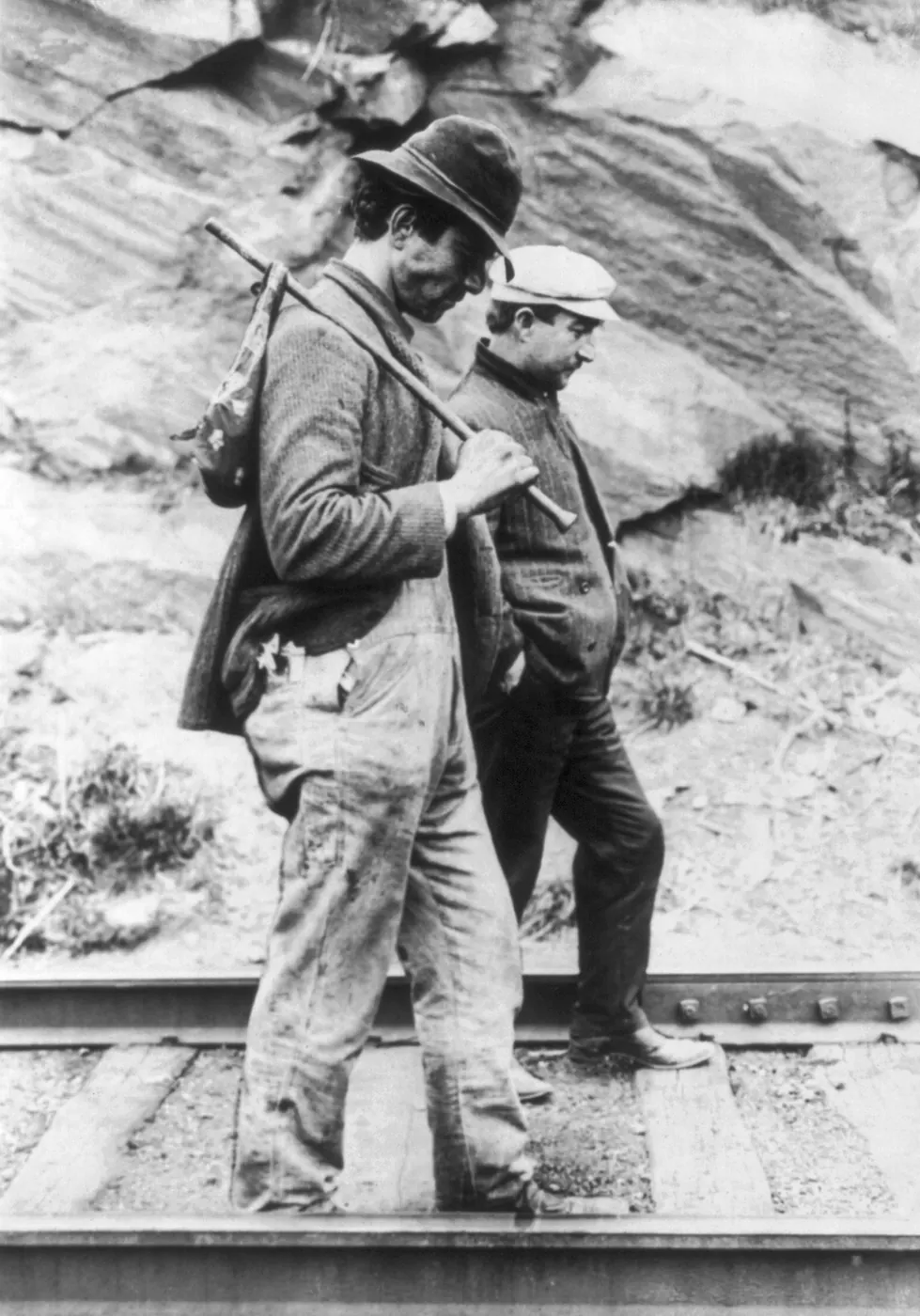 Two hobos walking along railroad tracks, after being put off a train